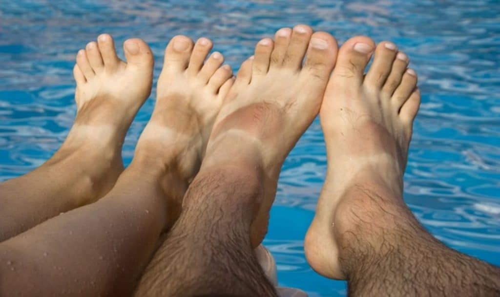 tanned bare feet of a man and a woman