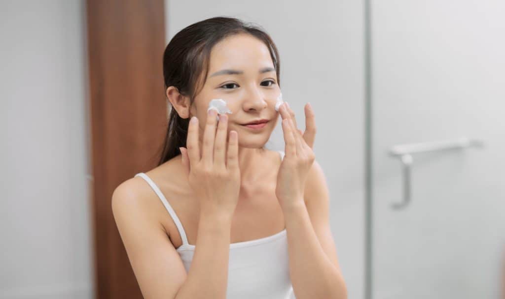 a happy beautiful korean double cleansing her face