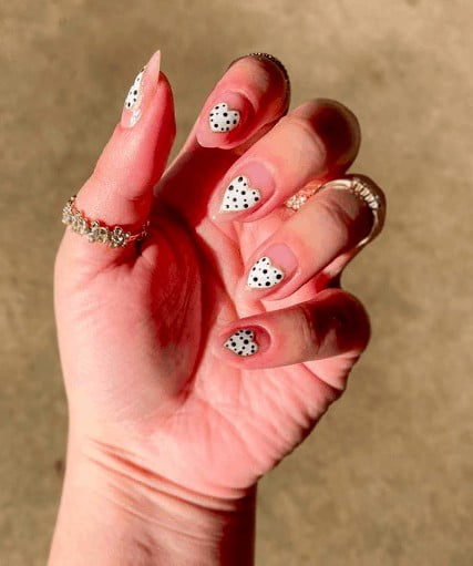 nude colored nails with white heart with polka dots