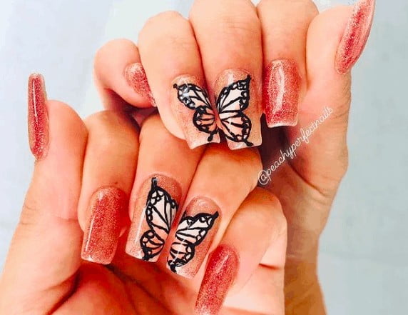glittered nails with black outlined butterflies
