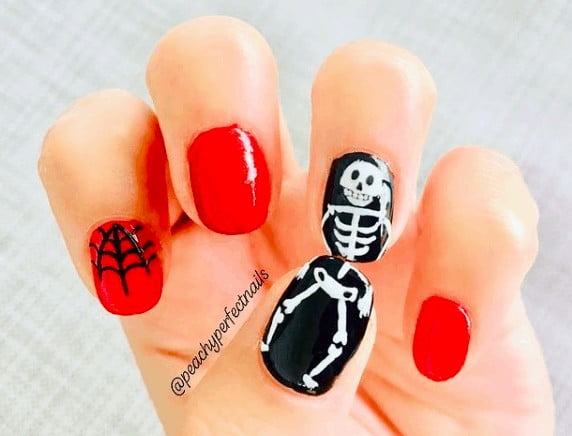 red and black nails with skeleton smiley face