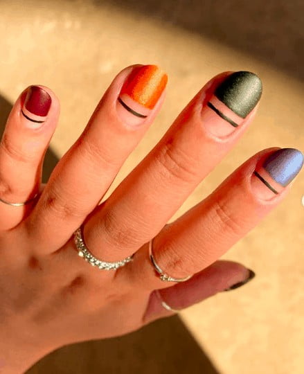 indie nail design consists of red, orange, green and blue with black lines below them