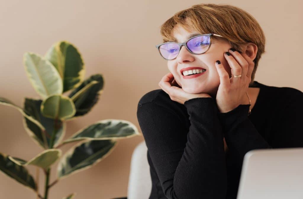 short hair lady with a reading glass smiling