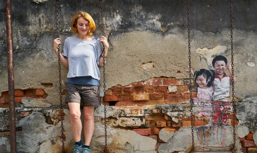 a blonde short hair lady standing on a swing