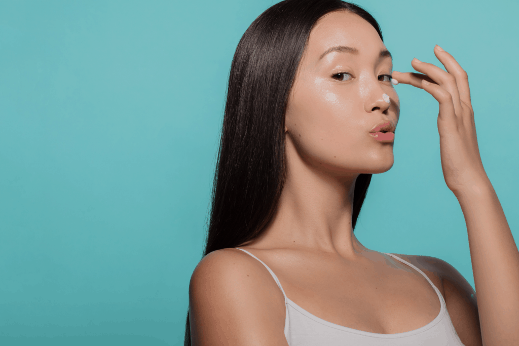 Korean lady gently putting moisturizer on her face