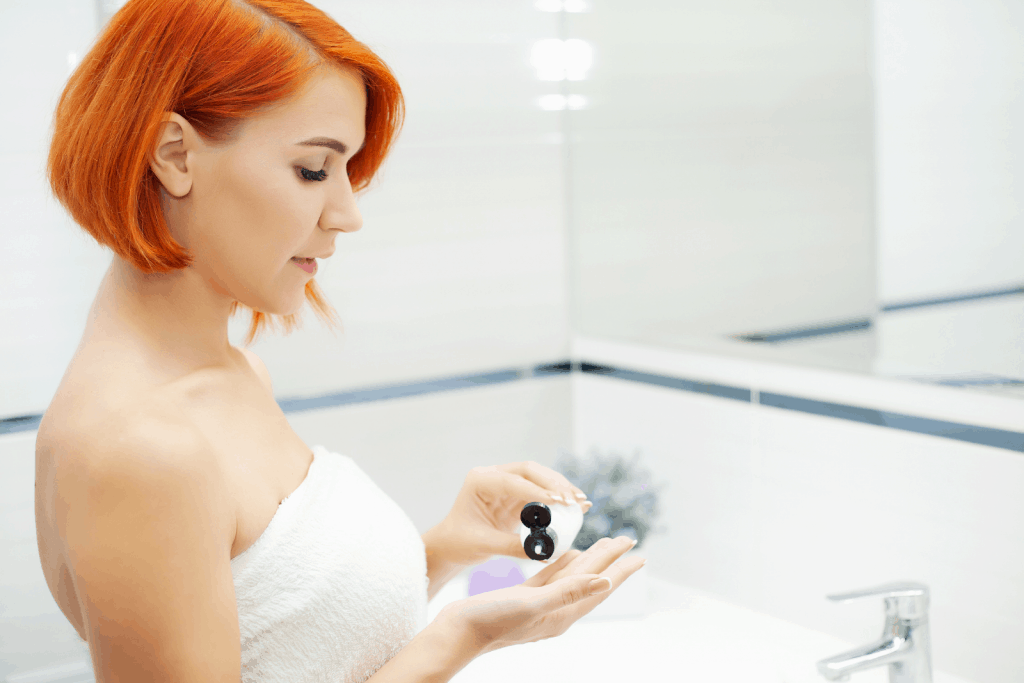 an orange-haired lady putting toner on her hands