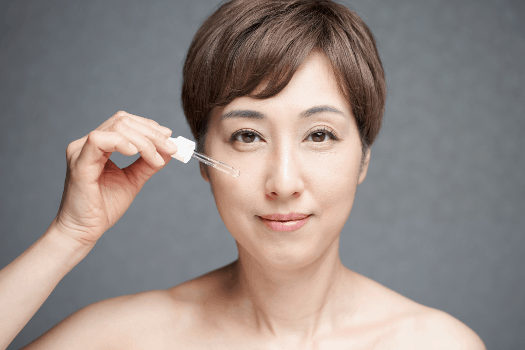 a middle-aged lady applying serum on her face