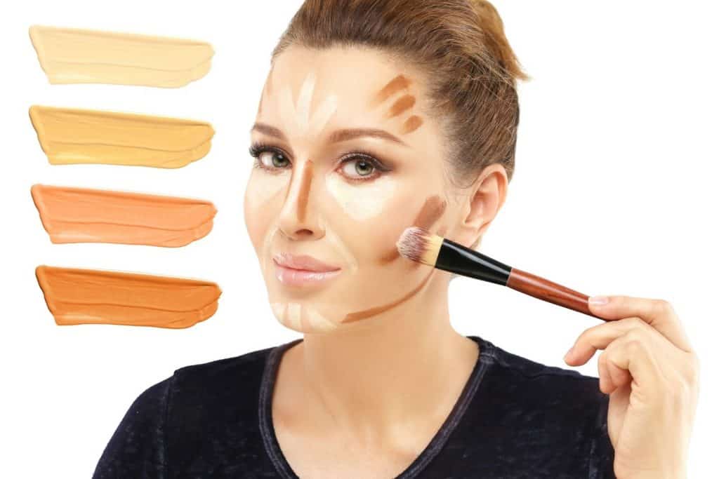 a gorgeous lady contouring her cheekbone using a blush brush