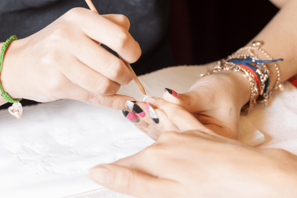 fiberglass vs acrylic nails: a lady putting fiberglass nails to her hands