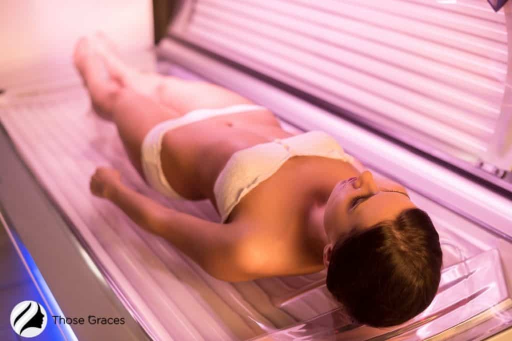 a woman in white bikini tanning in bed