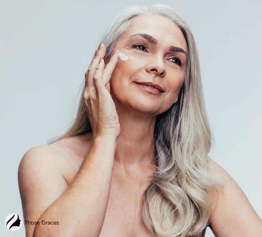 a senior woman putting anti-wrinkle cream under her eyes