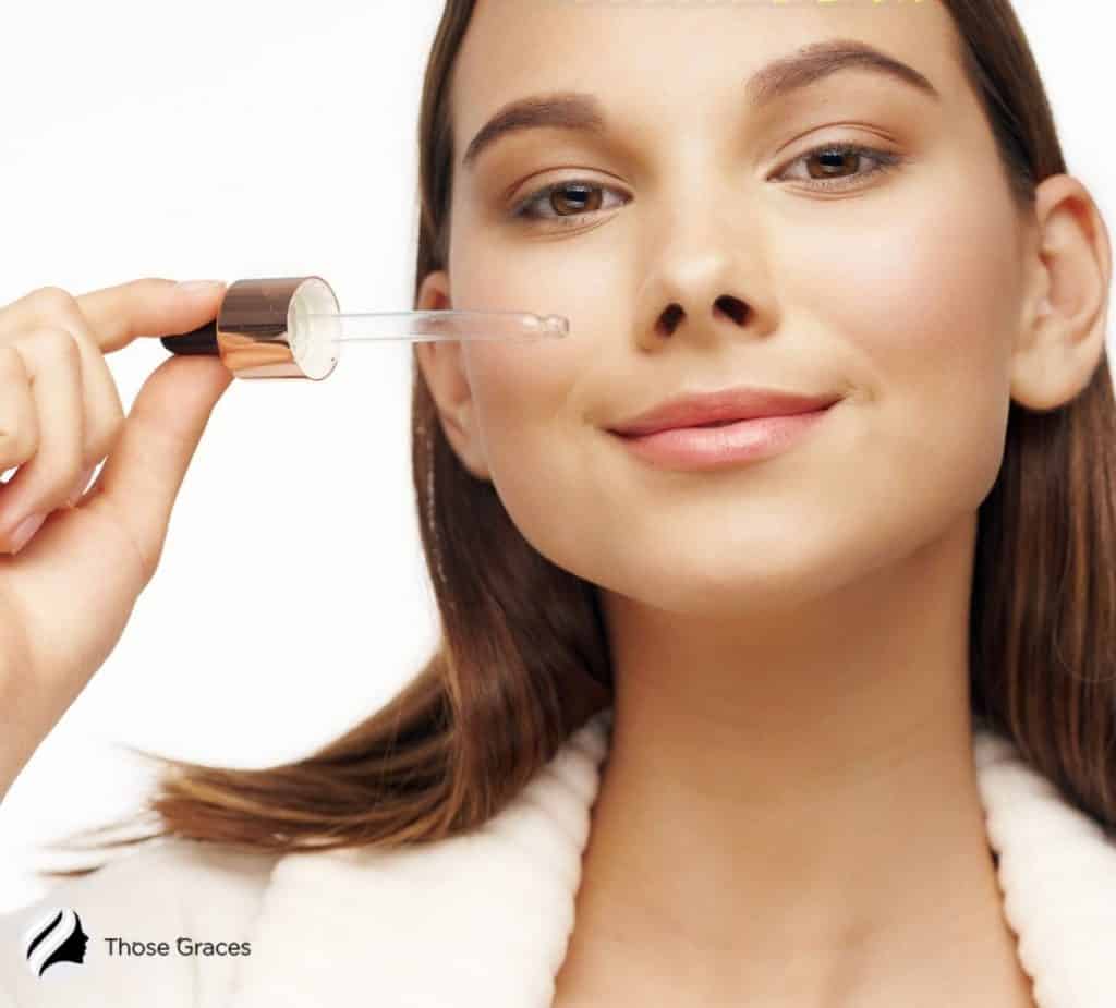 a lady putting a small amount of Korean ampoule on her face