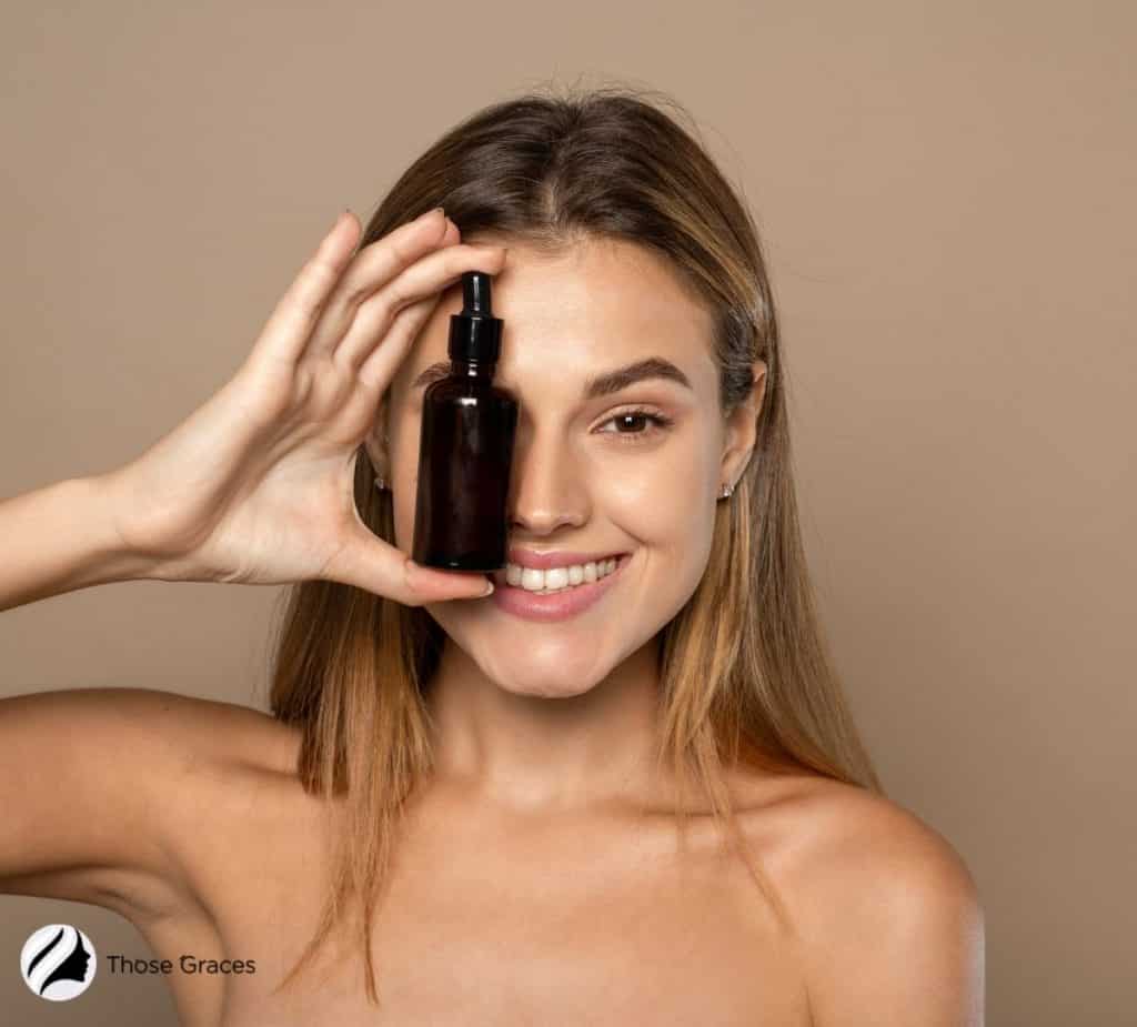 a lady holding a vitamin c serum right in front of her eye