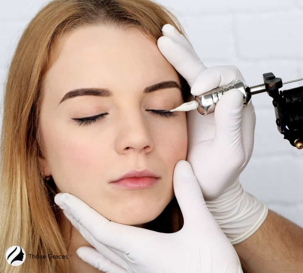 an expert putting a permanent makeup eyeliner to the lady's eyes