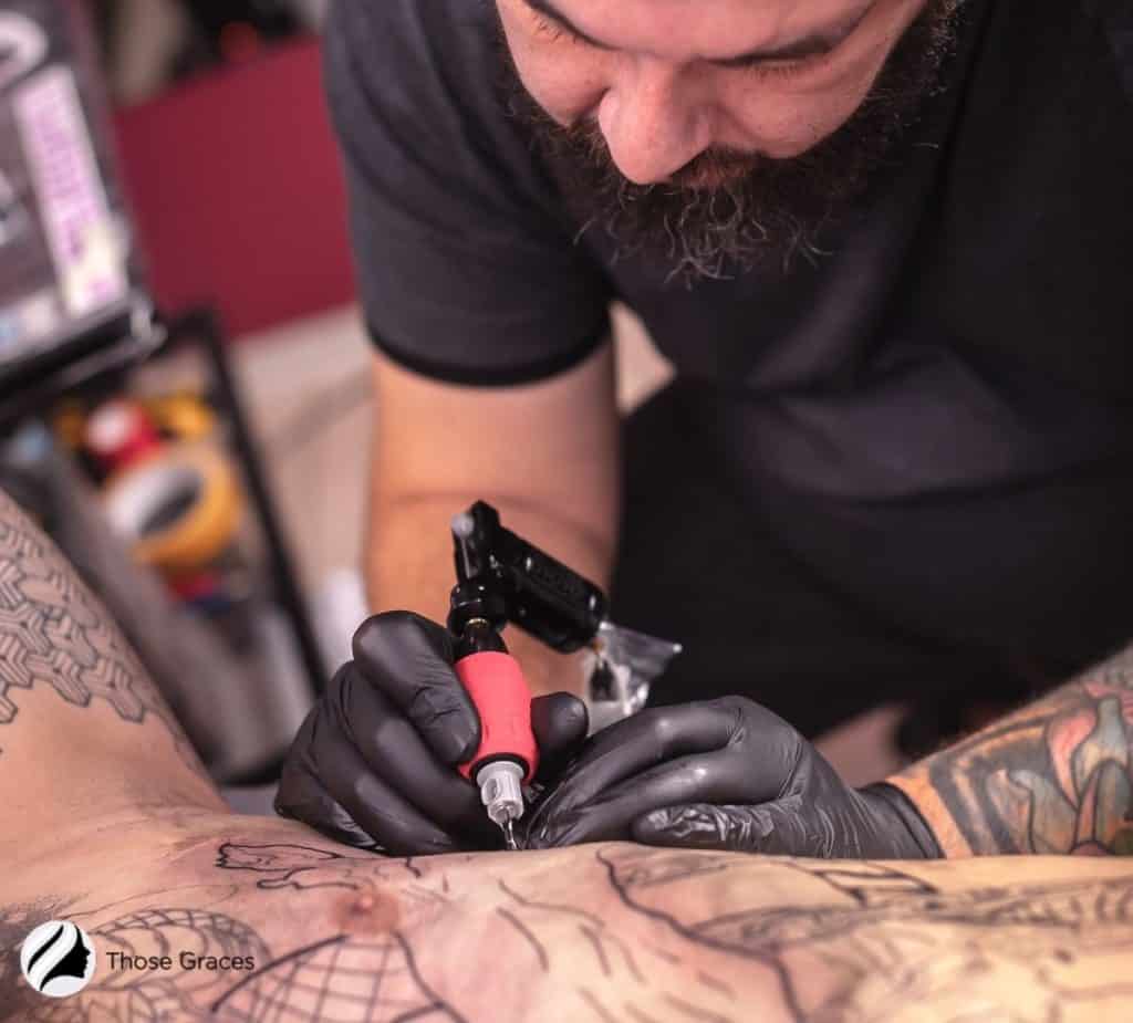 man putting tattoo on the body