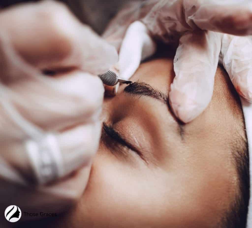 woman getting a microblading session for her brows: but what's the difference for eyebrow tattoo vs microblading