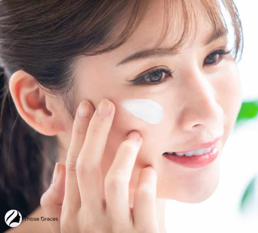 Korean girl demonstrating how to apply moisturizer on face