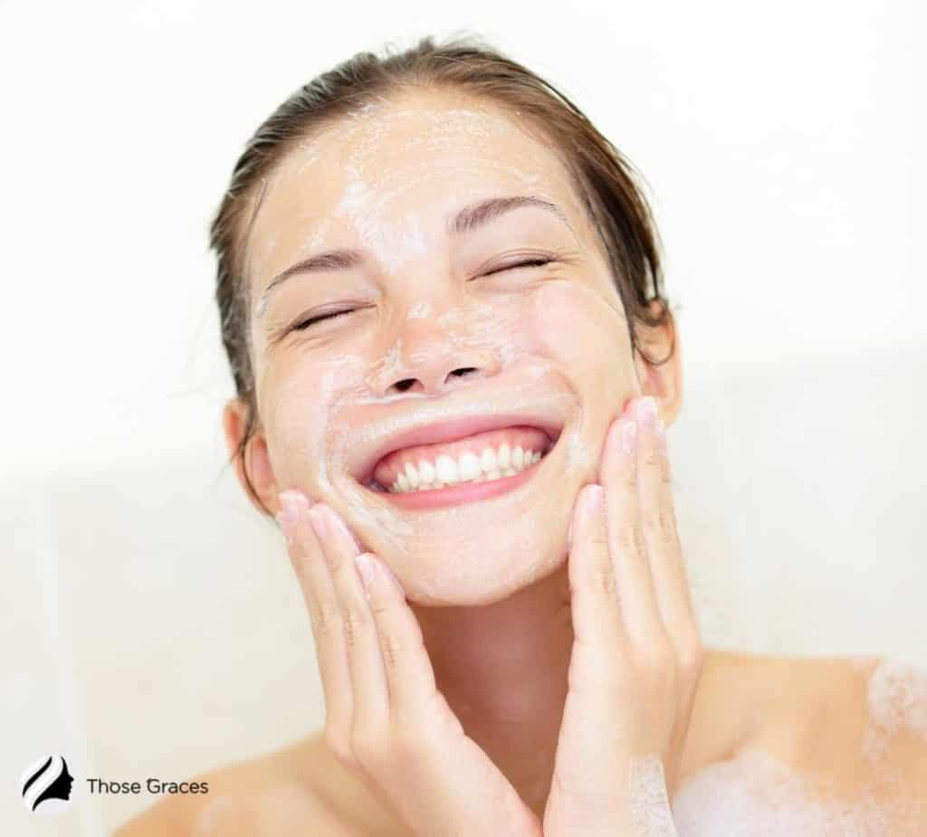 smiling woman cleansing face