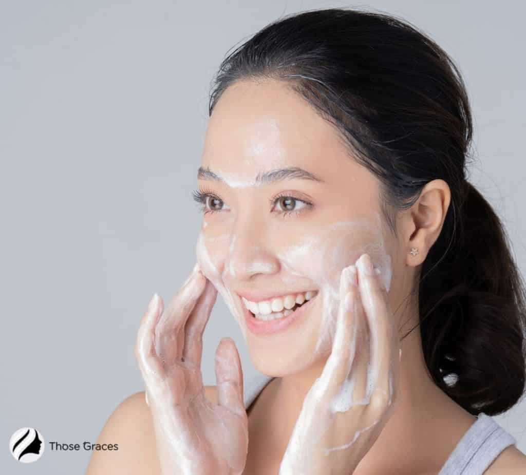 a girl applying cleanser on acne prone skin