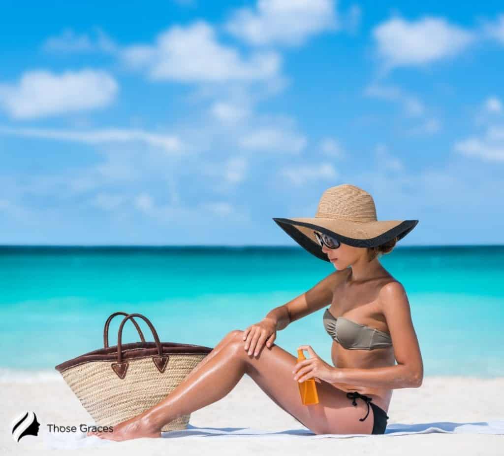 Lady applying suncreen on the beach