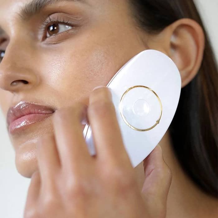 woman using ziip beauty device on her face