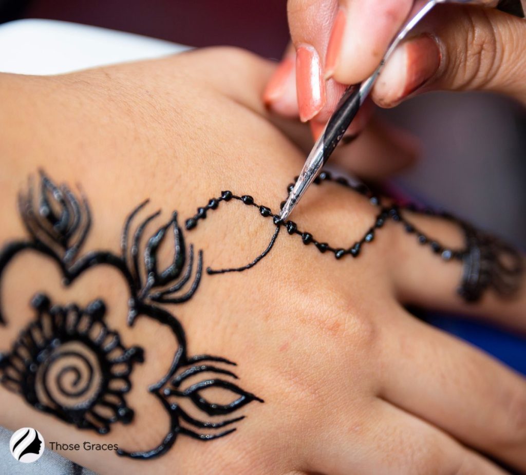 putting henna tattoo on the hand