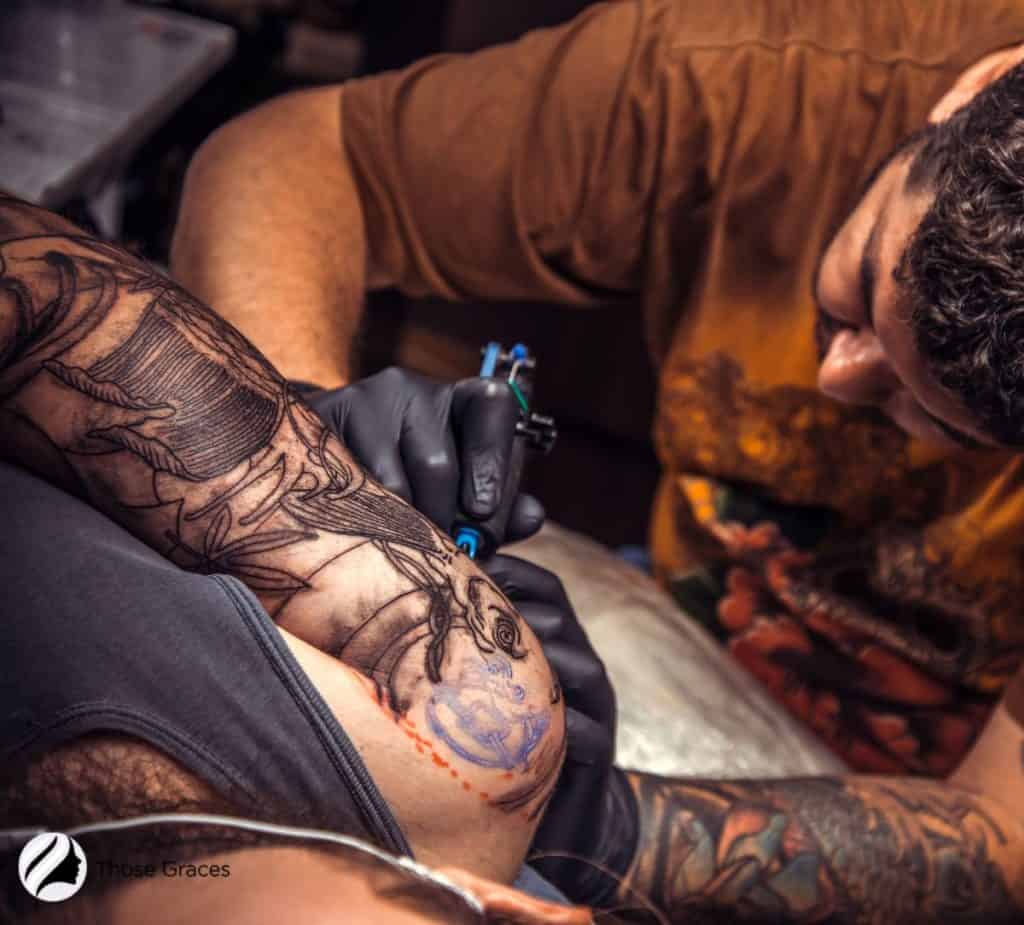 artist reusing a tattoo needle on men