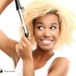 woman curling her blonde hair