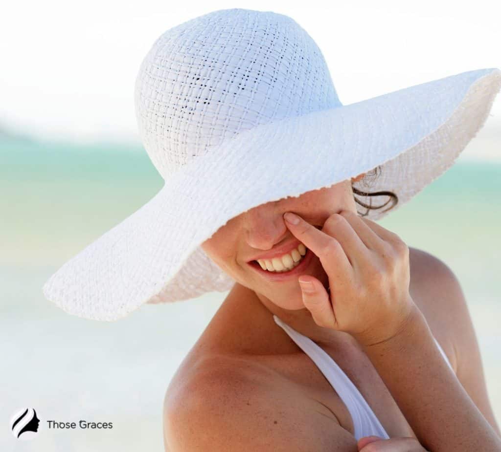 lady hiding her dark spots under a wide hat