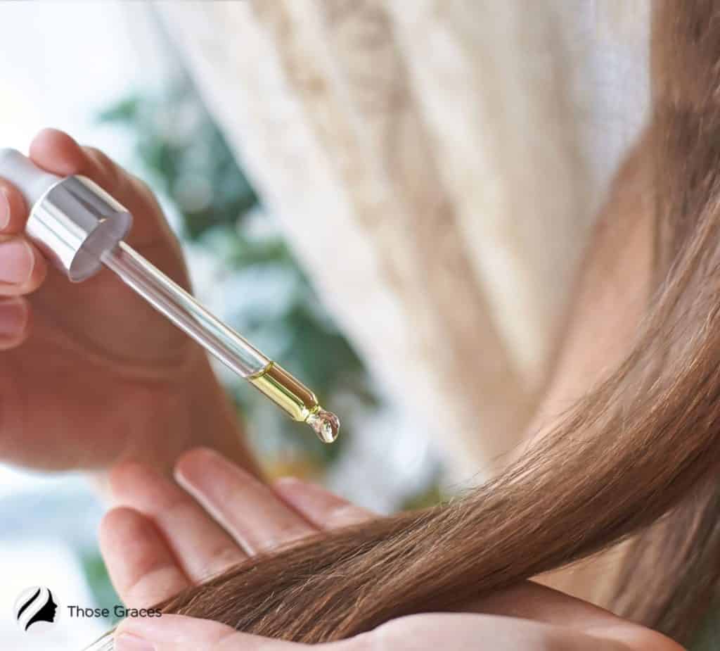 lady putting on argan oil on her hair tip