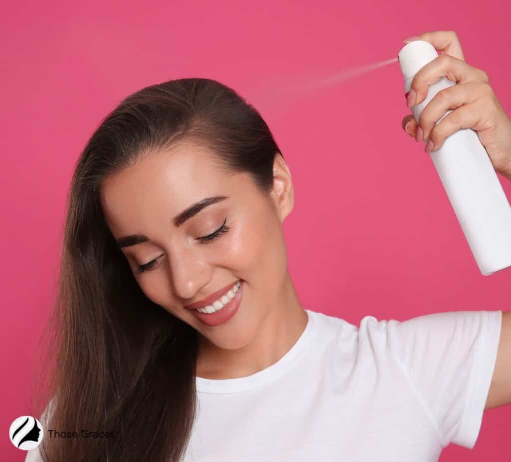 a woman using dry shampoo on her hair