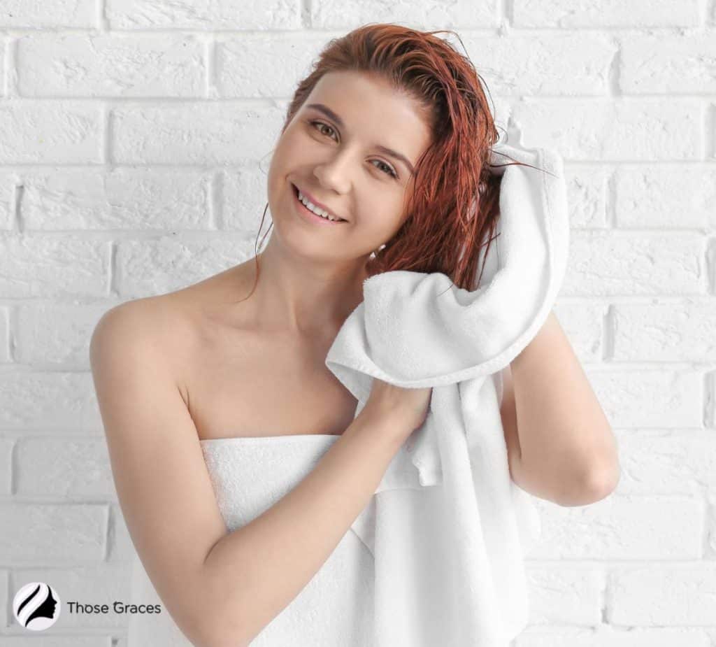 lady drying her hair using a microfiber towel