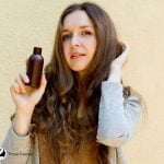 woman holding an argan oil shampoo