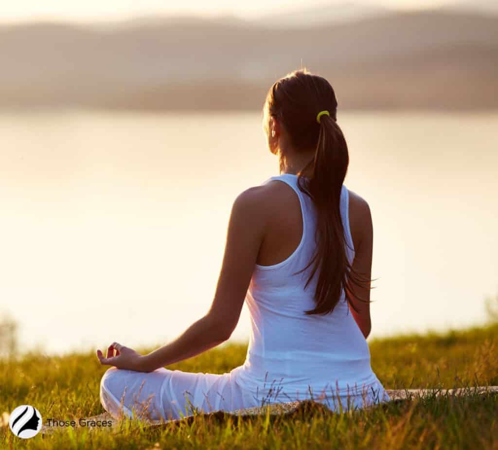 lady meditating in front of a lake