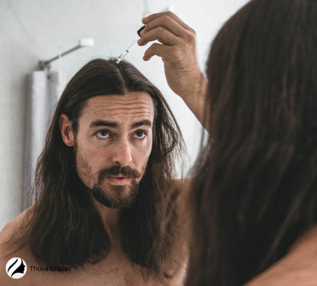 man applying hair serum