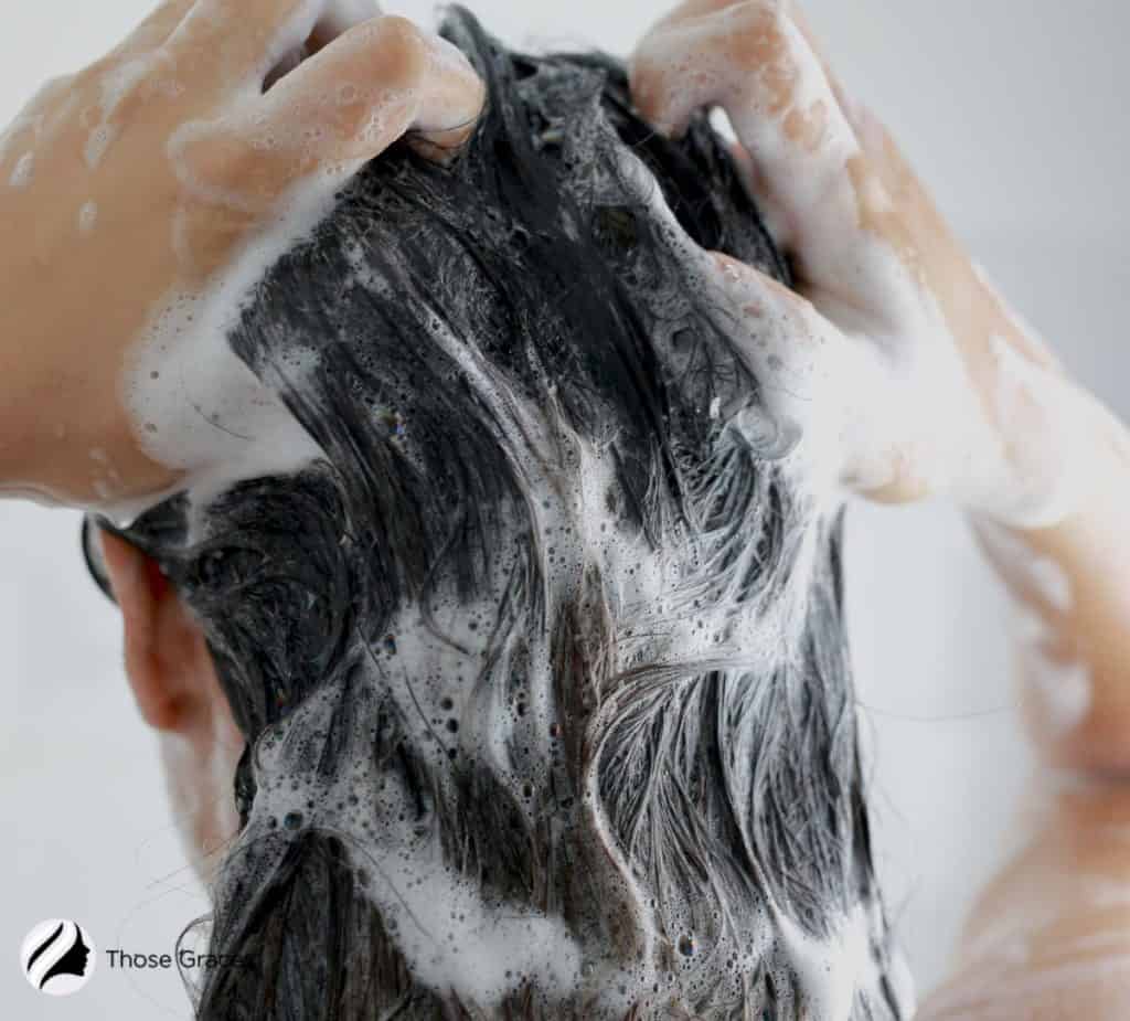 woman cleaning hair with shampoo